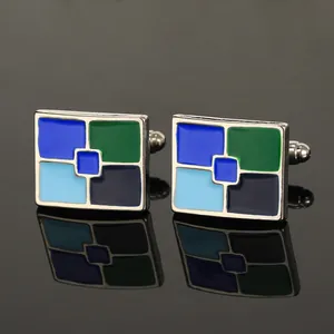 Macro-opname van rechthoekige zilveren manchetknopen met blauw en groen emaille patroon