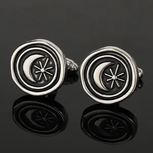 Macro shot of silver crescent moon and star cufflinks with vintage black enamel inlay