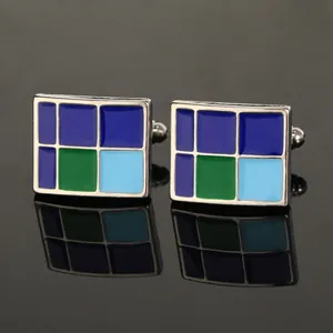 Gedetailleerde close-up van rechthoekige manchetknopen met blauw en groen emaille patroon