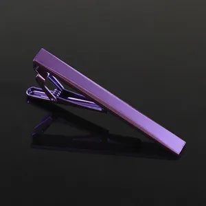 Macro view of a modern purple alloy tie clip with a sleek metallic finish and spring mechanism