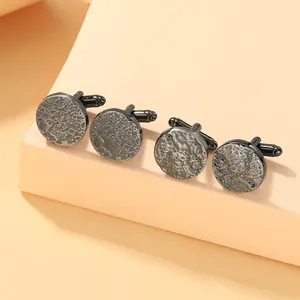 Detailed close-up of dark gunmetal round cufflinks with elegant hammered texture finish