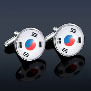 Polished silver cufflinks featuring South Korean flag design on a dark reflective surface