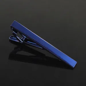 Close-up of sleek dark blue metallic tie clip with mirror finish on reflective surface