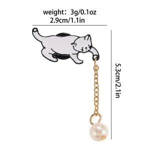Broche chat mignon en émail blanc avec chaîne dorée et perle pendante blanche