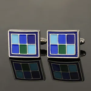 Zilveren vierkante manchetknopen met blauw emaille patroon op een zwart spiegeloppervlak
