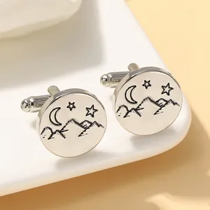Polished silver cufflinks featuring etched mountain, moon, and star patterns for men