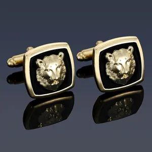 Macro detail of gold-tone cufflinks featuring a 3D lion head relief and black enamel finish