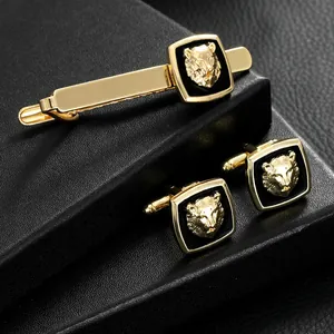Golden lion head cufflinks and tie clip set on elegant black textured background