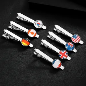 Selection of seven silver tie clips featuring national flags on a leather background