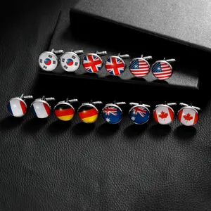 Polished silver cufflinks with various national flag designs on black leather background