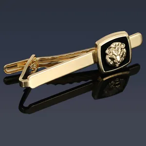 Detailed view of golden tie clip with lion head emblem on black square backing