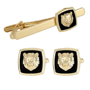 Business cufflinks and tie clip set with golden lion head relief on black background