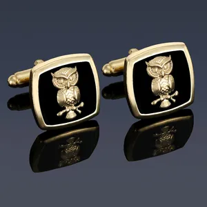 Macro view of gold cufflinks featuring 3D owl relief on black enamel surface