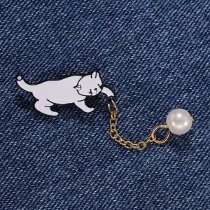 Broche chat dessin animé créative avec perle blanche et chaîne dorée sur fond denim