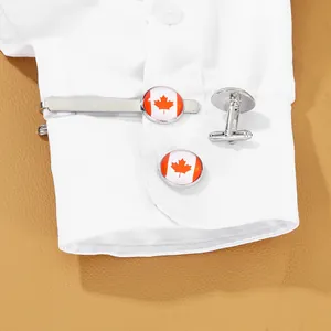 Close-up of silver tie clip and cufflinks set featuring the red Canada flag maple leaf logo