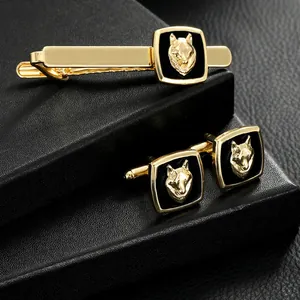Formal men's jewelry set with golden wolf head cufflinks and matching tie clip on leather