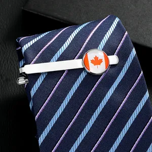 Detailed view of silver tie clip with Canadian flag emblem on a striped silk tie