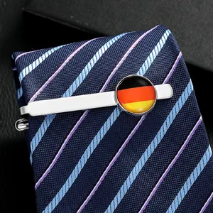 Close-up of a silver metal tie clip with a German flag emblem on a navy textured tie