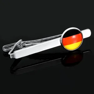 Detailed view of silver tie clip featuring a circular German flag emblem on black background