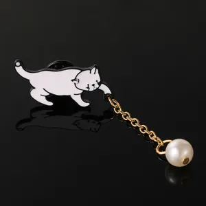 Détail de la broche chat créative avec chat émaillé, chaîne dorée et pendentif perle blanche