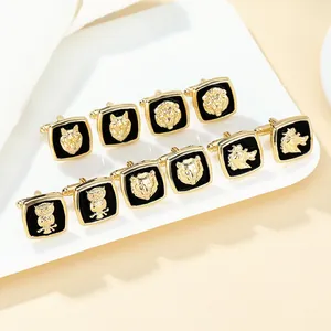 Men's gold animal head cufflinks with black enamel on white display stand