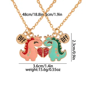 Matching BFF dinosaur crown heart necklaces with gold chains and magnetic pendants