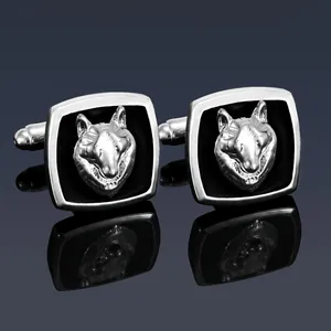 Close-up of silver men's business cufflinks with a 3D wolf head relief on black enamel