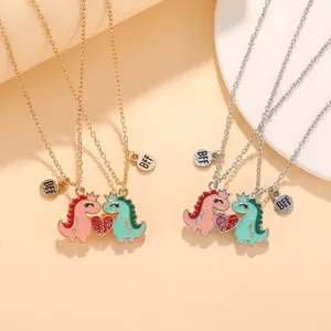 Detail of magnetic heart-shaped cartoon dinosaur pendants on gold and silver BFF necklaces