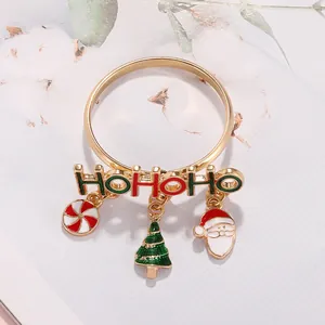 Macro shot of gold napkin ring featuring HOHOHO lettering and Christmas themed charms