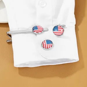 Detail view of silver cufflinks and tie clip set with American flag pattern on white shirt