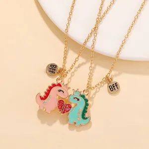 Close-up of magnetic dinosaur necklaces with enamel pendants and a BFF heart charm