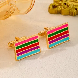 Macro detail of gold cufflinks with colorful enamel stripes on a premium textured surface