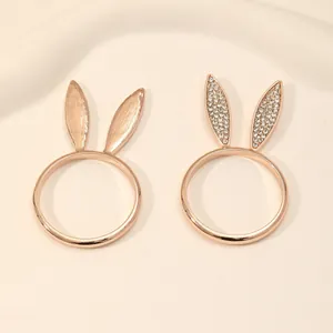 Detailed macro view of rose gold bunny ear napkin rings with crystals and smooth finish