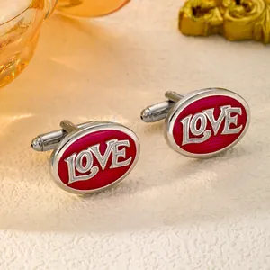 Macro detail of silver oval cufflinks with red enamel finish and LOVE embossed lettering