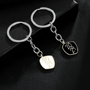 Close-up of 2024 graduation keychains with gold-trimmed black and white enamel alloy charms