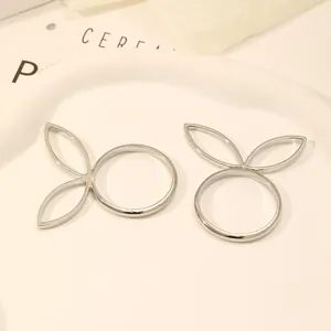 Detailed macro view of silver bunny ear napkin rings on a white ceramic plate