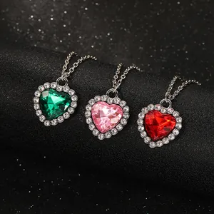 Vista detallada de collares de cristal con forma de corazón en esmeralda, rosa y rojo