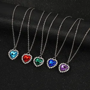 Primer plano de varios collares con colgante de corazón de colores sobre terciopelo negro