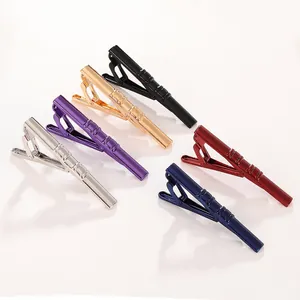 Close-up of polished metal tie clips in six colors with elegant diagonal stripe patterns