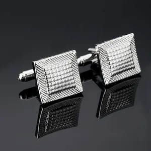 Détail macro de boutons de manchette carrés argentés avec motif de grille gravé noir