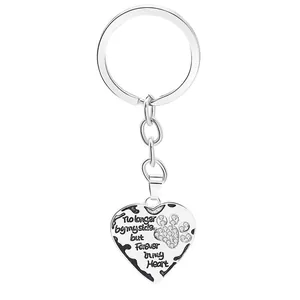 Detail of silver heart keychain with paw print and pet memorial quote and rhinestones
