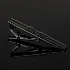 Close-up of black metallic necktie clip with decorative horizontal twill texture