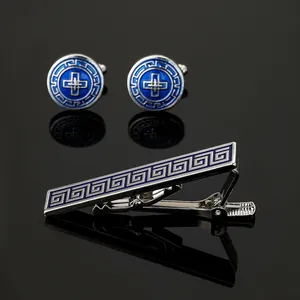 Detail of silver cufflinks and tie clip set with blue Greek meander pattern and enamel