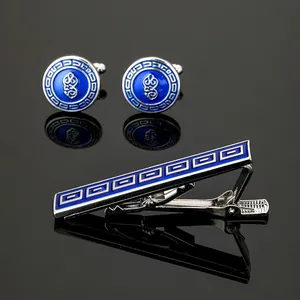 Close-up of silver cufflinks and tie clip set with blue enamel and Greek key pattern