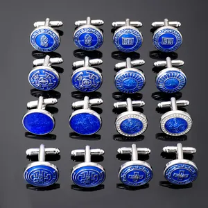 Macro display of silver cufflinks collection with blue enamel patterns on black background