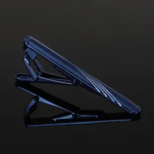 Detailed view of navy blue striped metal tie clip with high-polish finish on dark background
