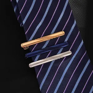 Three-piece metal tie clip set in gold silver and blue with spiral texture on a necktie