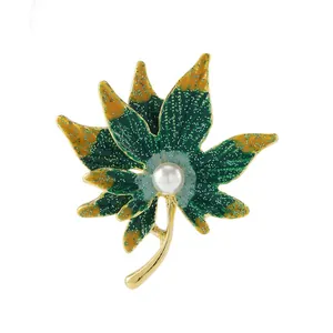 Detail of maple leaf brooch with green enamel, gold plating and central pearl