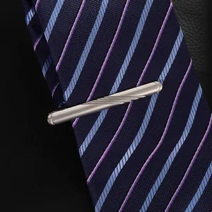 Macro shot of silver tie clip with twist texture on a blue striped business tie