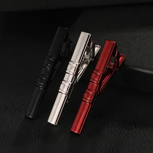 Detailed view of black, silver, and red metal tie clips with textured stripes on leather